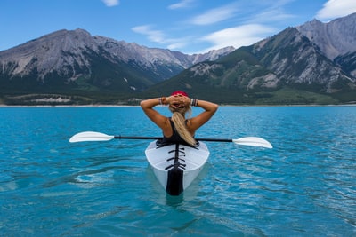 女人骑kayak在海的中间
